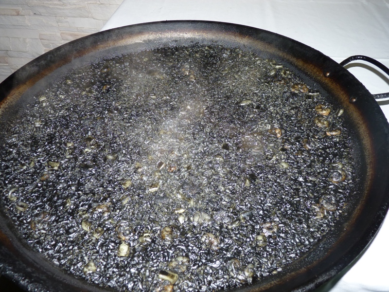 Arroz Negro humeante en Paella