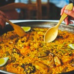 Valencian paella and wooden spoons of orange tree